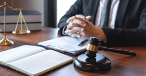 Nursing home lawyer at a desk with notebooks, a gavel, and the scales of justice.