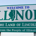 Welcome to Illinois sign featuring the outline of the state and the text 'The Land of Lincoln' and 'From the People of Illinois'.